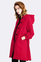 Red water resistant oversized hooded windbreaker rain jacket for women with button closure and pockets