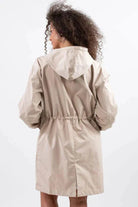 Beige water resistant oversized hooded windbreaker jacket from back view