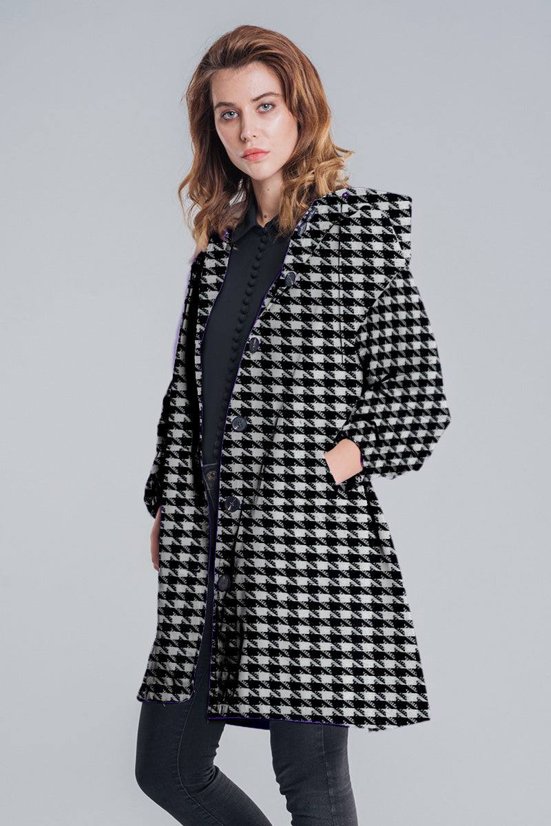 Woman wearing black and white houndstooth water resistant oversized windbreaker jacket with hands in pockets