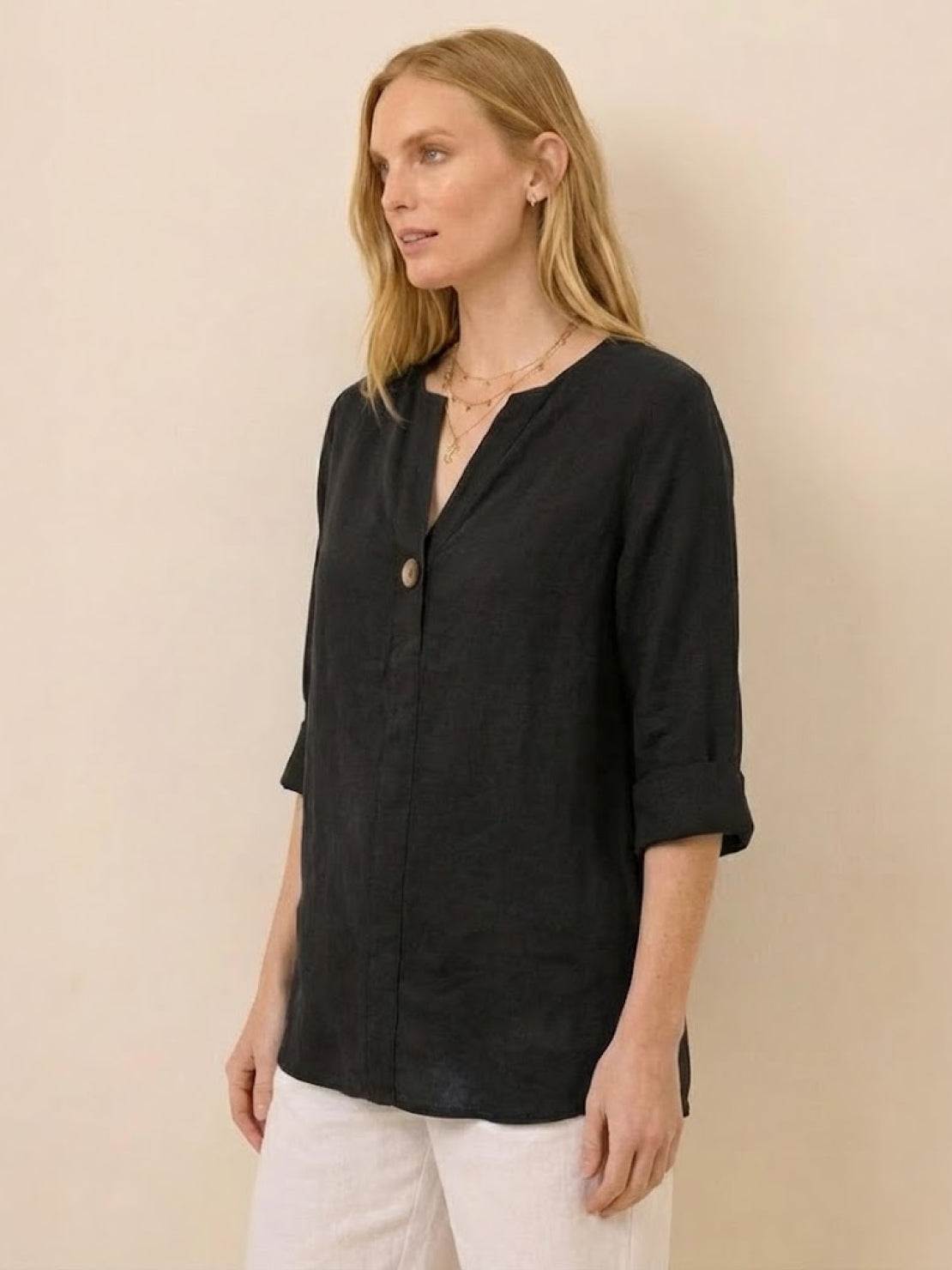 Woman wearing black pure linen age-defying shirt with button detail and rolled sleeves