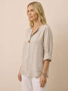 Woman wearing beige pure linen age-defying shirt with button detail and rolled sleeves