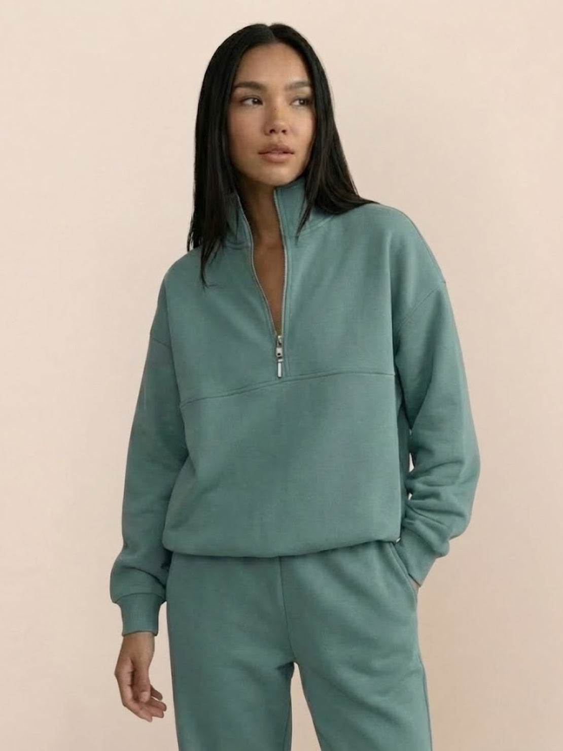 Woman wearing a cotton-blended two-piece tracksuit with high collar and zipper, showcasing athleisure style and comfort