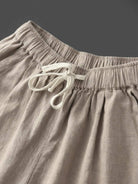 Woman wearing breezy relaxed fit straight pants standing outdoors with greenery in the background