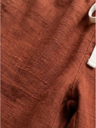 woman wearing orange relaxed fit straight pants standing outdoors with casual shoes