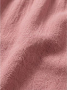 Woman wearing capped-sleeve voluminous pleated midi dress with pockets and flowing skirt