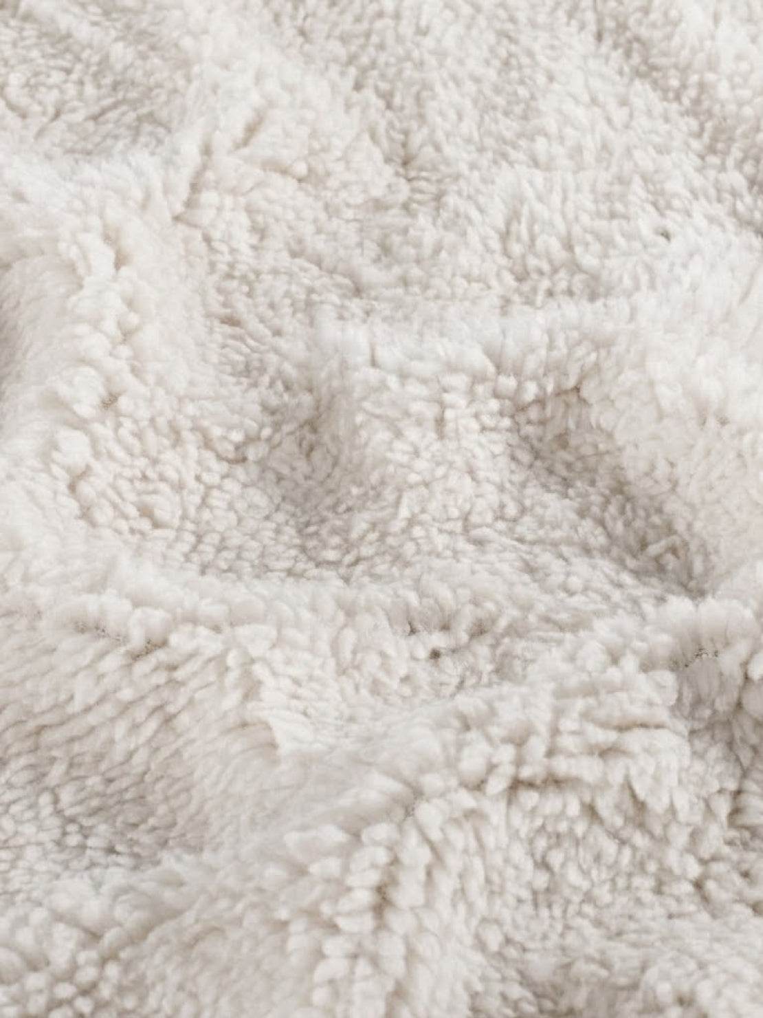 Close-up of soft white sherpa fabric texture for everyday wear oversized coat lining