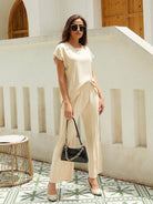Woman wearing a wrinkle-resistant, pleated two-piece travel set made from breathable viscose-acrylic blend, embodying first class travel comfort and elegance