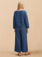 Women wearing loose solid color blue two-piece set with long sleeves and wide-leg pants back view