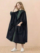 One size oversized black waterproof windbreaker jacket with hood and large pockets worn by woman