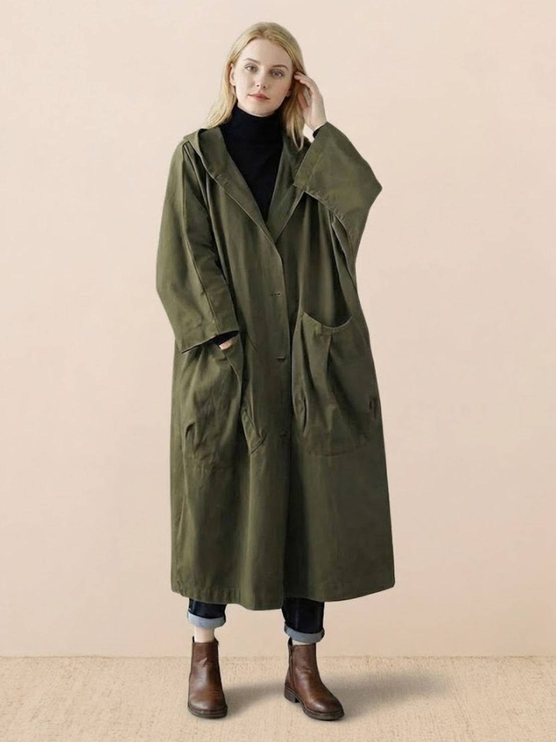 Oversized olive green waterproof windbreaker jacket with hood and large front pockets worn by woman