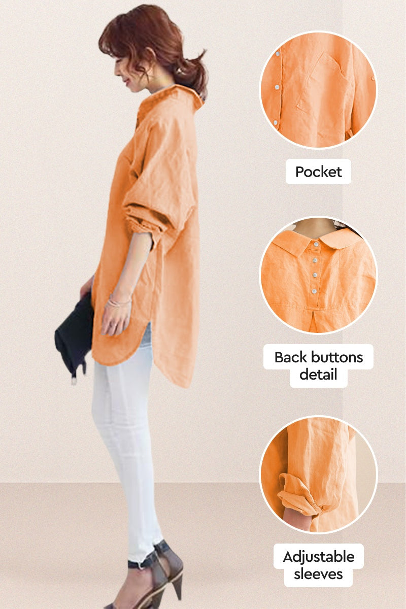 Woman wearing oversized linen shirt in sun-washed pink with back button detail and adjustable sleeves, styled with white pants and heels.