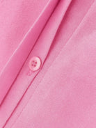 Close-up of pink oversized 100% cotton shirt fabric and button