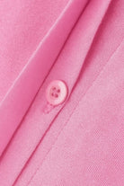 Close-up of pink oversized 100% cotton shirt fabric and button detail