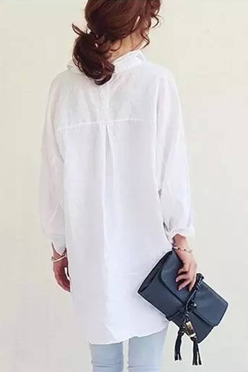Back view of woman wearing oversized white linen shirt holding a black handbag