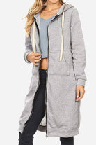 Woman wearing gray oversized long zip sweatshirt hoodie with drawstring hood and front pockets