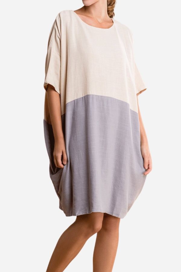 Woman wearing oversized color block T-shirt dress in beige and gray with loose fit and short sleeves