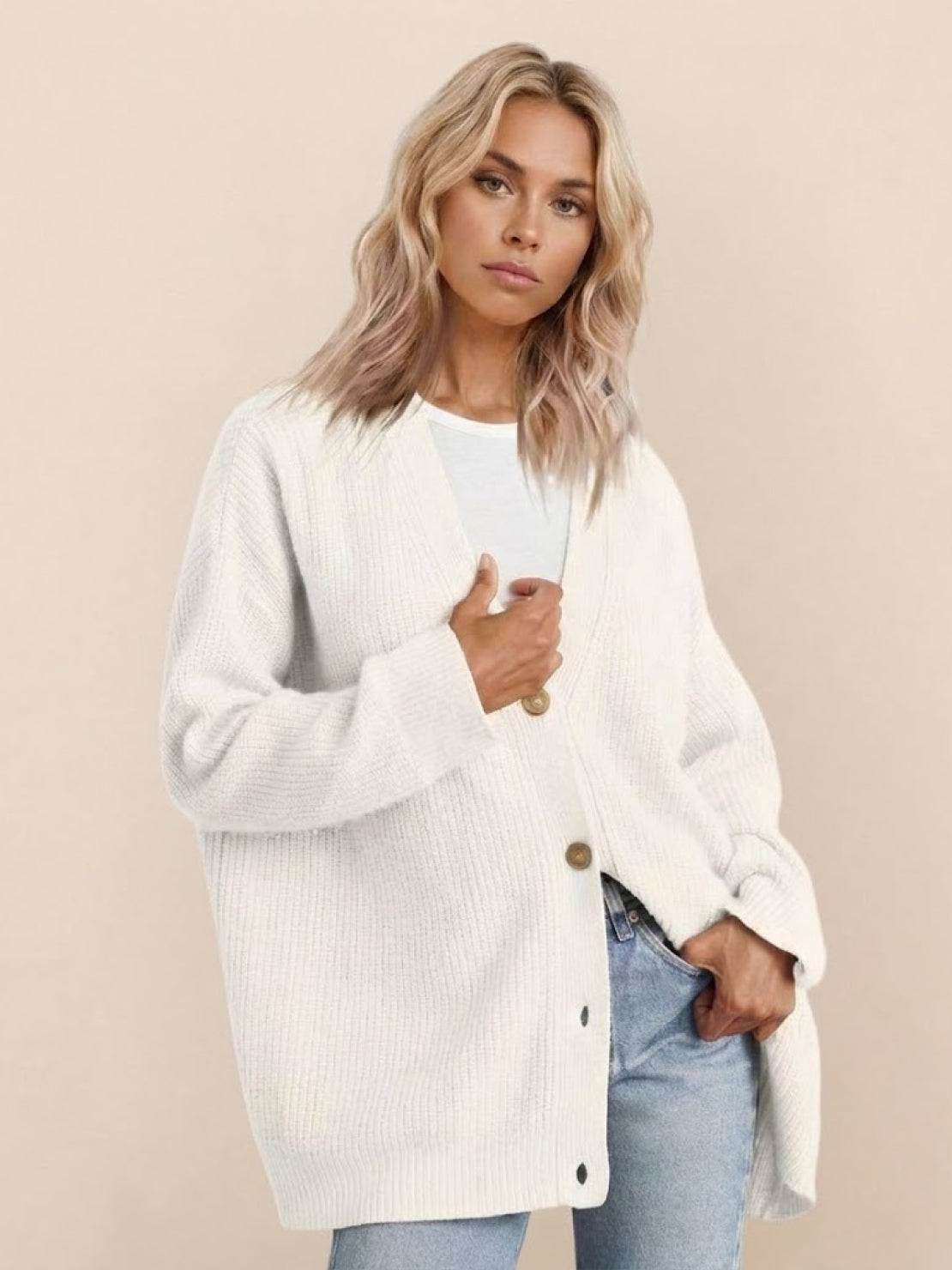 Relaxed fit oversized white knit cardigan with button down front worn by woman