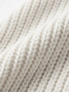 Close-up of soft, white relaxed fit oversized knitwear cardigan fabric texture
