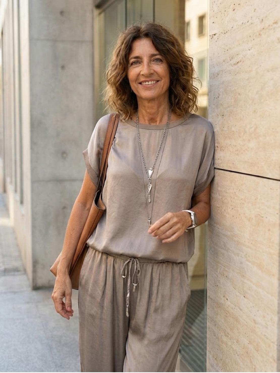 Woman wearing Silken Escape satin two-piece set with wide-leg pants and slim top in flowing fabric