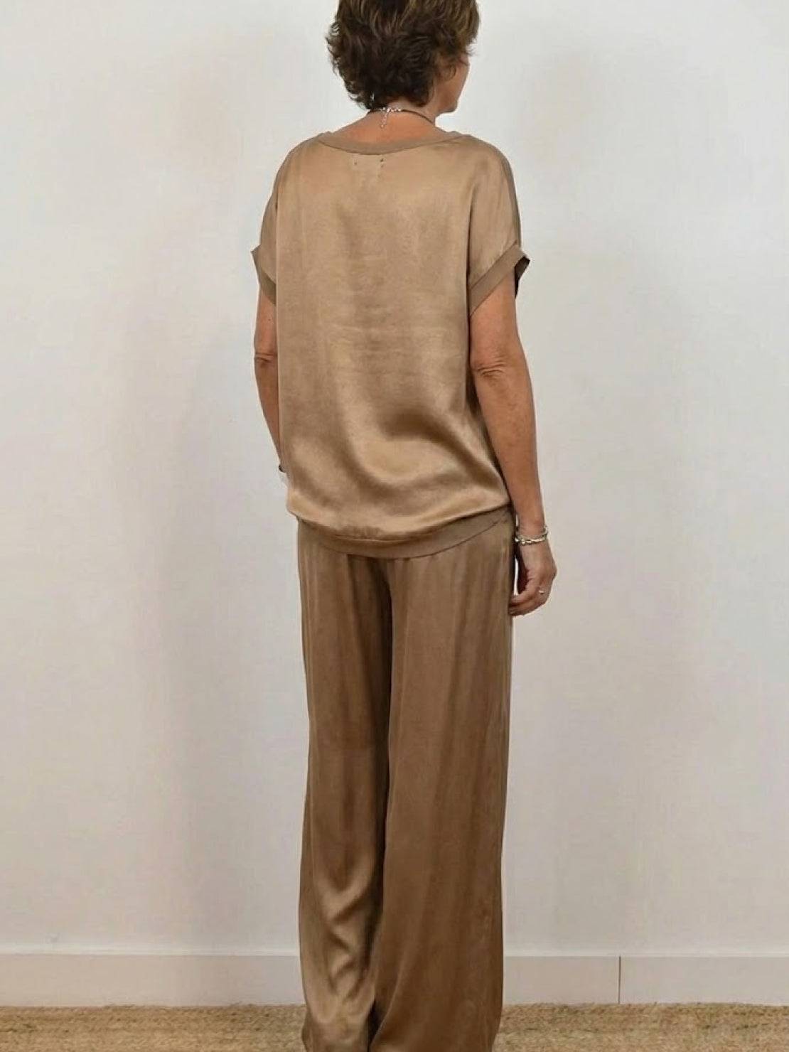 Model wearing Silken Escape Satin Two-Piece Set with flowing top and wide-leg pants in elegant satin fabric