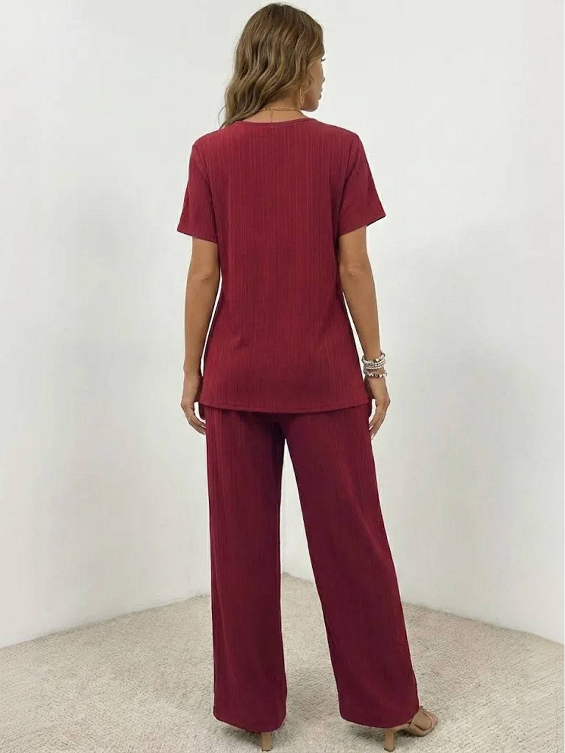 Woman wearing Textured Elegance two-piece set with asymmetrical top and wide-leg pants in soft stretch fabric