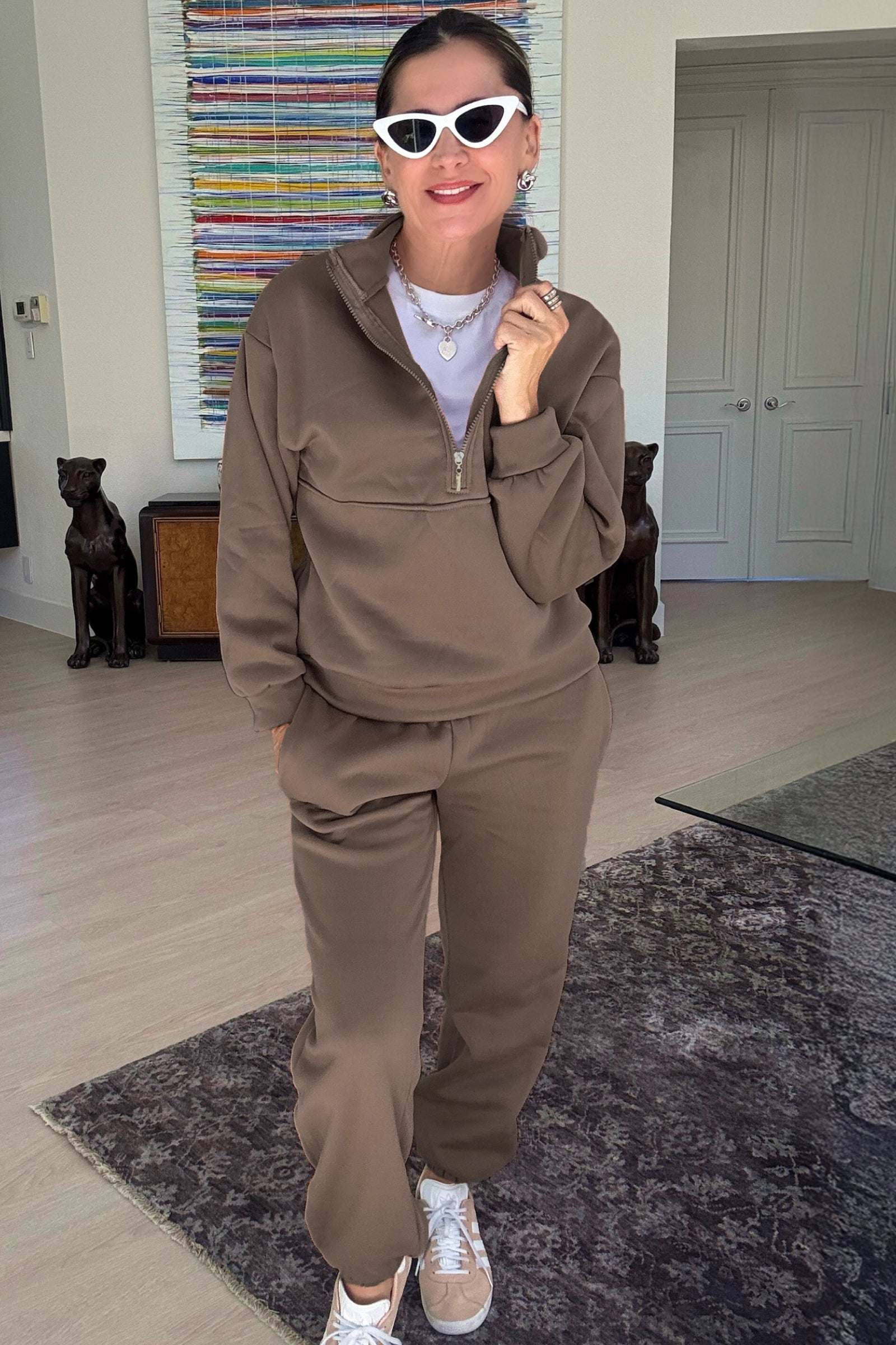 Woman wearing a brown cotton blend tracksuit with a half-zip pullover and matching pants indoors