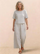 Woman wearing a loose fit co-ord set with a soft-tailored top and wide-leg bottoms in solid color