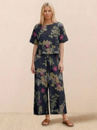 Woman wearing floral loose fit co-ord set with short sleeves and wide-leg pants