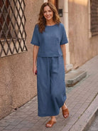 Woman wearing blue loose fit co-ord set with wide-leg pants and short-sleeve top on city street