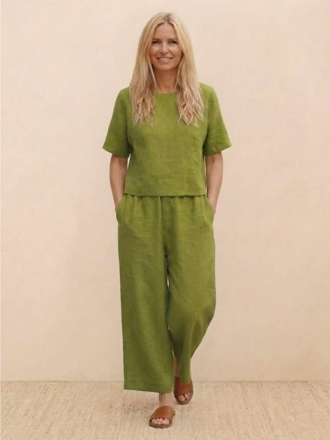Woman wearing olive green loose fit co-ord set with short sleeves and wide-leg trousers.