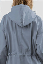 Back view of a light blue Rain Couture Windbreaker with an adjustable hood and cinched waist, made from water-resistant fabric.