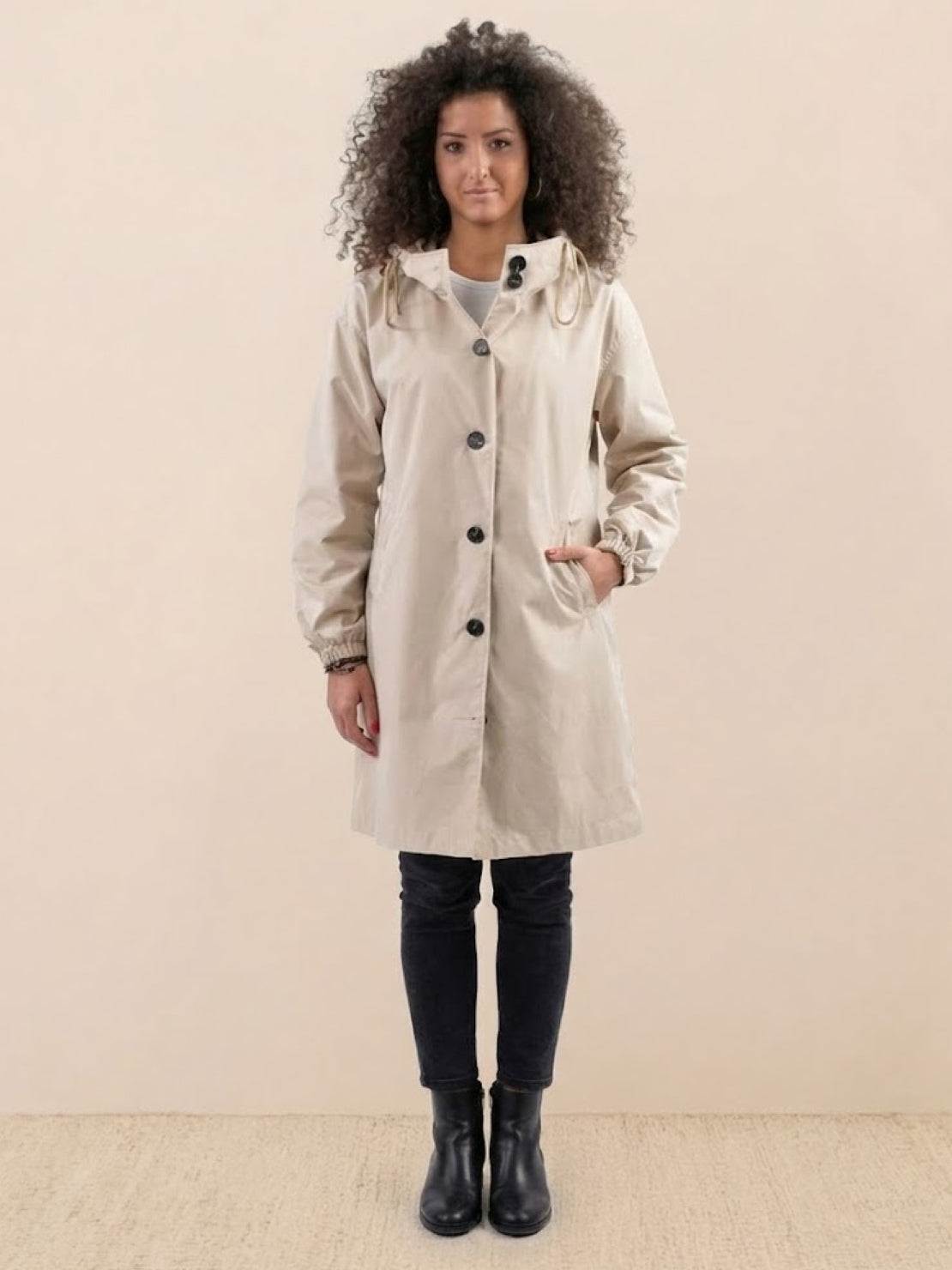 Woman wearing beige Rain Couture Windbreaker with oversized fit and water-resistant fabric.