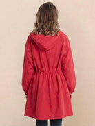 Woman wearing red Rain Couture Windbreaker oversized water-resistant jacket with adjustable hood, back view
