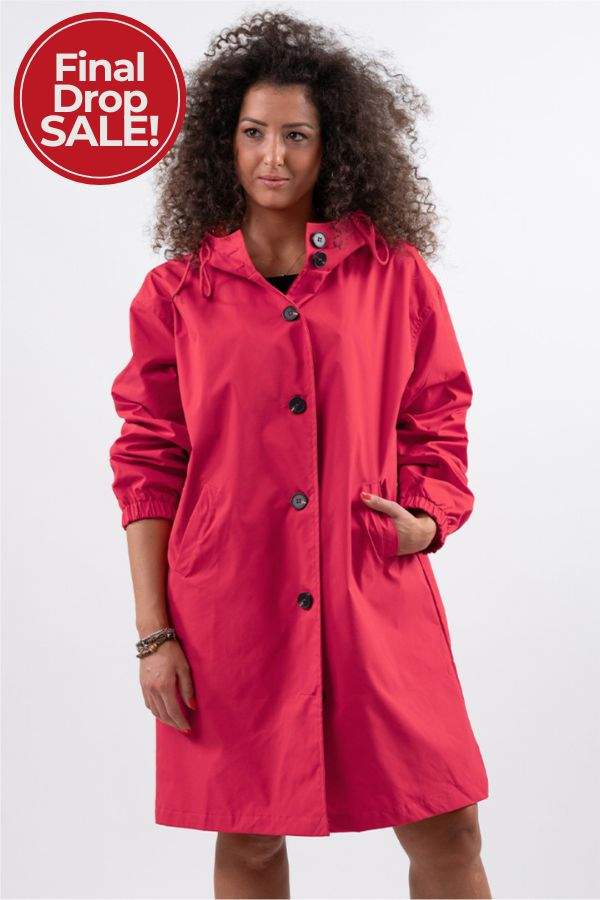 Woman wearing red Rain Couture Windbreaker oversized water-resistant jacket with hood and pockets