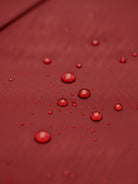 Woman wearing elegant water-repellent rain A-line hooded coat with belt outdoors