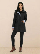 woman wearing black water resistant windbreaker hooded rain jacket with pockets and rolled cuffs